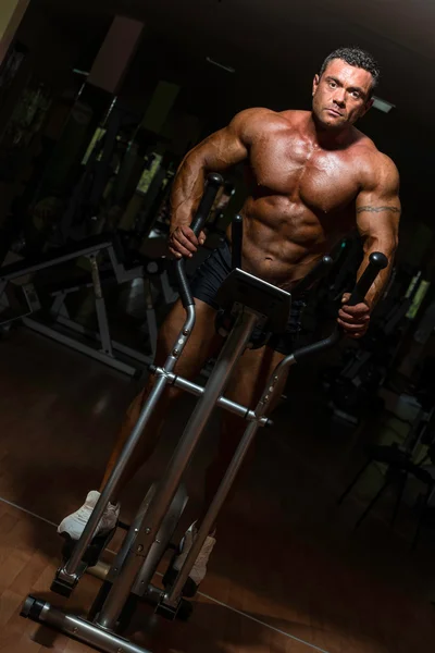 Male bodybuilder using the elliptical machine — Stock Photo, Image