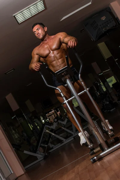 Bodybuilder maschile utilizzando la macchina ellittica — Foto Stock
