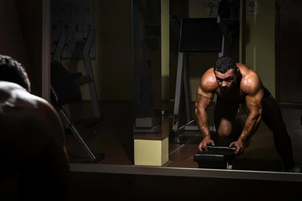 背部のための重い重量運動をしている男性のボディービルダー — ストック写真