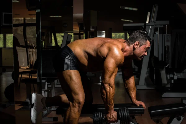 Male bodybuilder doing heavy weight exercise for back — Stock Photo, Image