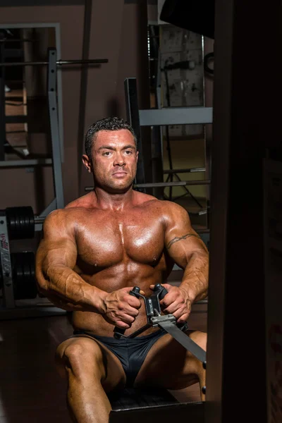 Male bodybuilder doing heavy weight exercise for back