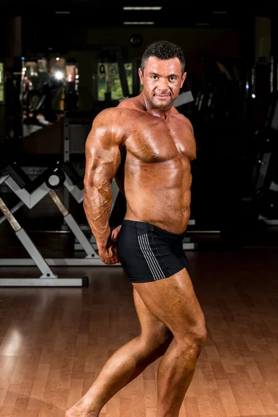 Muscular bodybuilder showing his side triceps — Stock Photo, Image