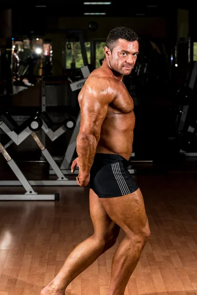 Muscular bodybuilder showing his side triceps — Stock Photo, Image