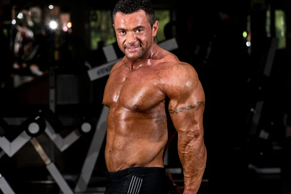 Gespierde bodybuilder tonen van zijn kant triceps — Stockfoto