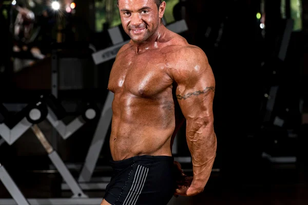 Gespierde bodybuilder tonen van zijn kant triceps — Stockfoto