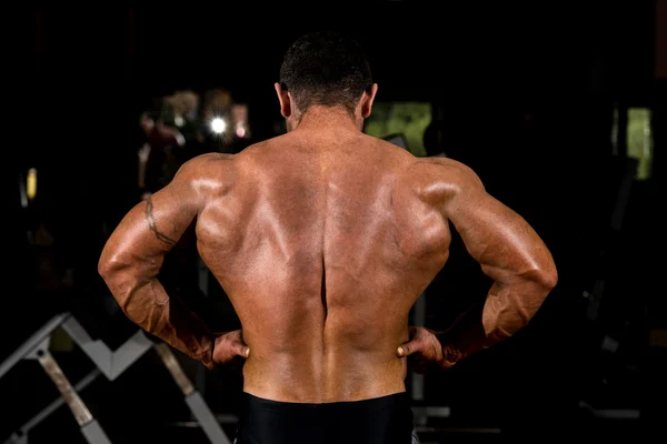 Muskulöser Bodybuilder zeigt Rückenstreckung — Stockfoto