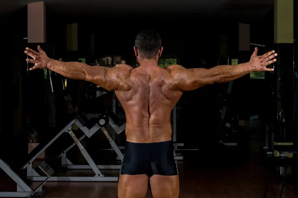 Mannelijke lichaam bouwer met zijn armen — Stockfoto