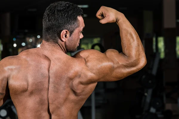 Masculino fisiculturista mostrando seu bíceps — Fotografia de Stock