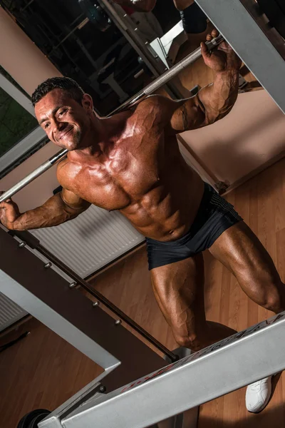 Body builder doing squat with barbell — Stock Photo, Image