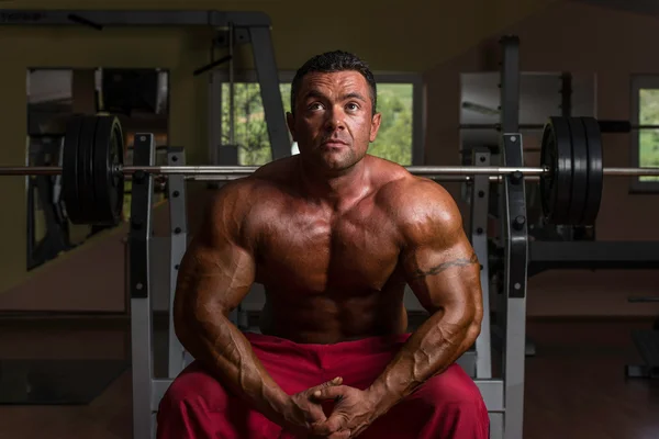 Hemdsloser Bodybuilder ruht sich auf der Bank aus — Stockfoto