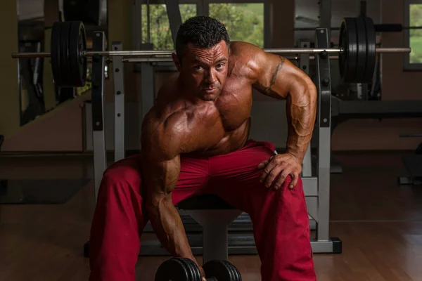 Fisicoculturista sin camisa haciendo ejercicio pesado para bíceps — Foto de Stock