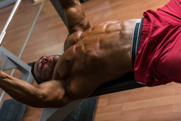 Sin camisa culturista haciendo press de banca para el pecho — Foto de Stock