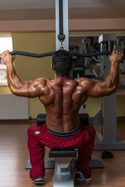 Shirtless bodybuilder doing heavy weight exercise for back — Stock Photo, Image