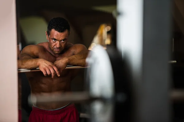 Bodybuilder resting after doing heavy weight exercise — Stock Photo, Image