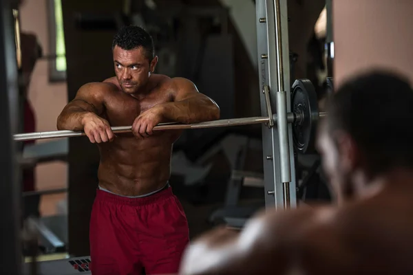 Bodybuilder resting after doing heavy weight exercise — Stock Photo, Image