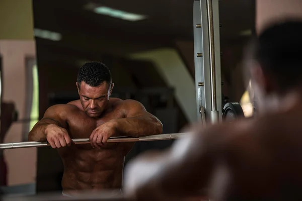 Bodybuilder resting after doing heavy weight exercise — Stock Photo, Image