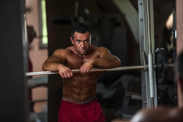 Bodybuilder resting after doing heavy weight exercise — Stock Photo, Image