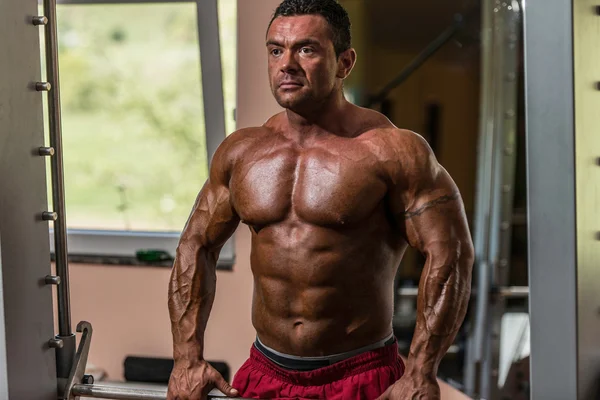 Male bodybuilder doing heavy weight exercise for trap — Stock Photo, Image