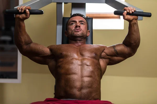 Male bodybuilder doing heavy weight exercise for upper chest — Stock Photo, Image