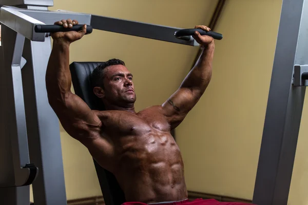 Male bodybuilder doing heavy weight exercise for upper chest — Stock Photo, Image