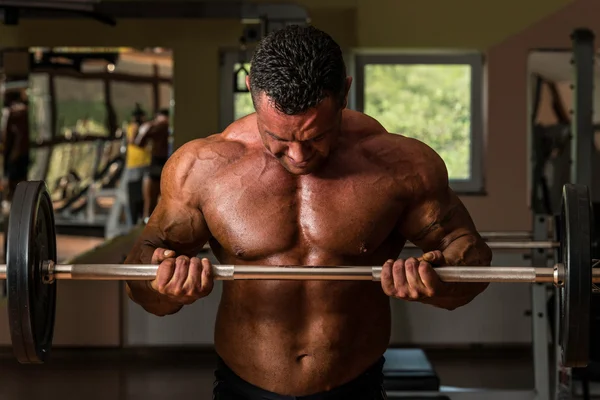 Kulturysta robi ciężar ćwiczeń na biceps z brzana — Zdjęcie stockowe