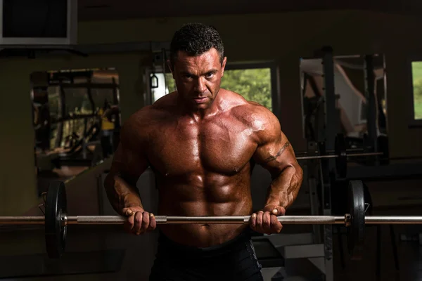 Bodybuilder doen zware gewicht oefening voor biceps met barbell — Stockfoto