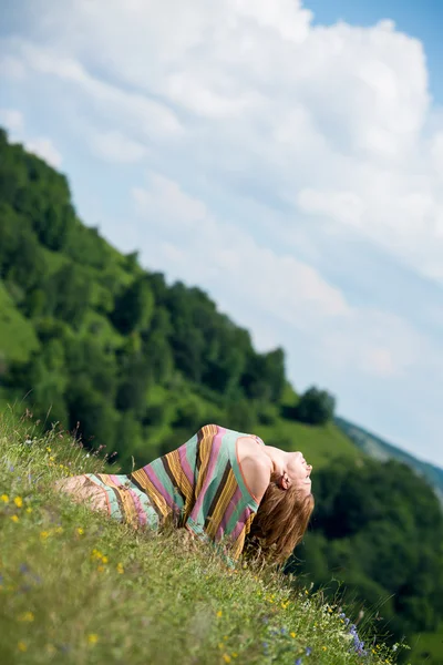 Beautiful woman in dress sitting on the grass — Stock Photo, Image