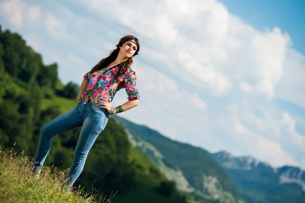 Hermosa mujer en jeans de pie sobre la hierba — Foto de Stock