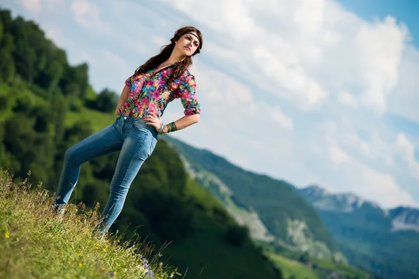 Vacker kvinna i jeans står på gräset — Stockfoto