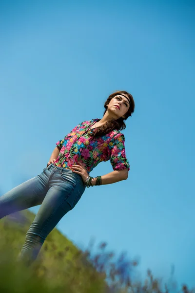 Красивая женщина в джинсах стоит на траве — стоковое фото