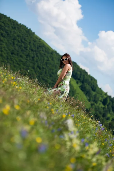 Içinde çimlerde oturan genç kadın — Stok fotoğraf