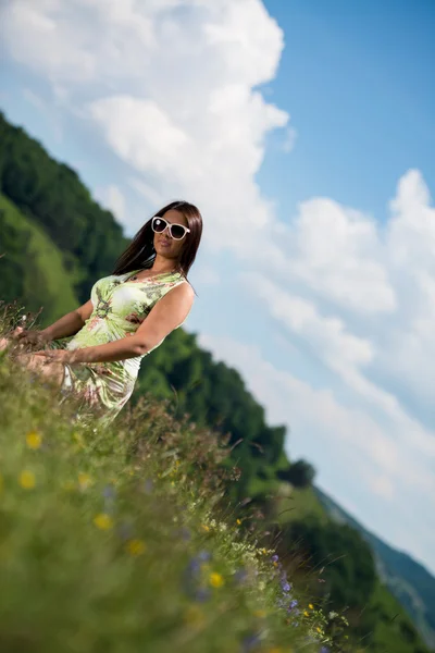 Mujer joven en vestido sentado en la hierba — Foto de Stock