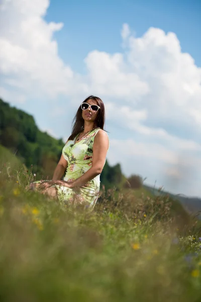 Young woman in dress sitting on the grass — Stock Photo, Image