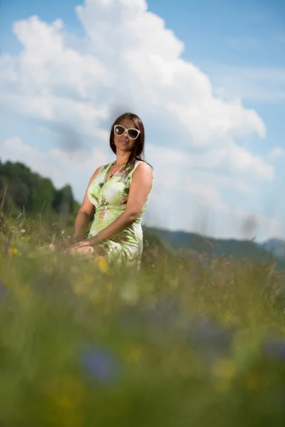 Young woman in dress sitting on the grass — Stock Photo, Image