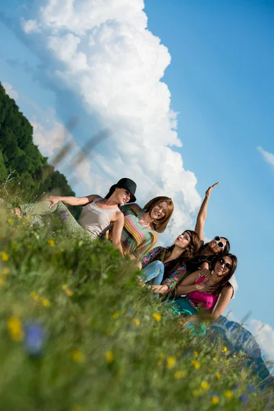 Çimenlerin üzerinde oturan ve having fun kız grubu — Stok fotoğraf