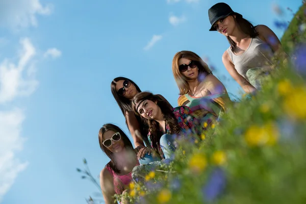 Groupe de filles assis sur l'herbe et avoir du plaisir — Photo