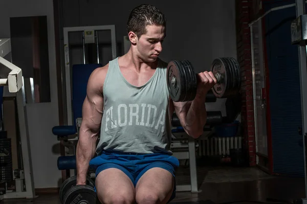 Joven culturista haciendo ejercicio de peso pesado para bíceps con du — Foto de Stock