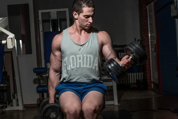 Young bodybuilder doing heavy weight exercise for biceps with du — Stock Photo, Image