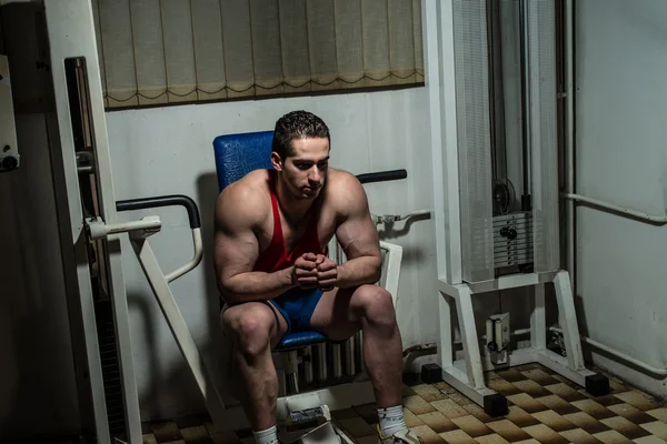 Junger Bodybuilder ruht sich auf der Bank aus — Stockfoto