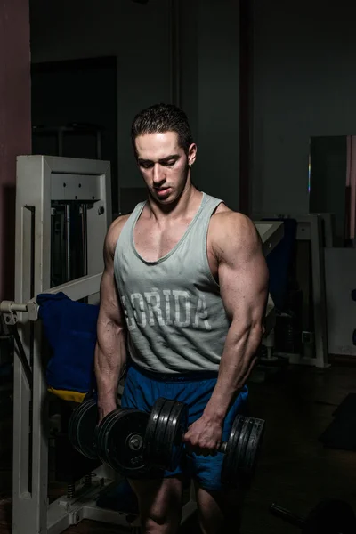 Bodybuilder doing heavy weight exercise for shoulder white dumbbell — Stock Photo, Image