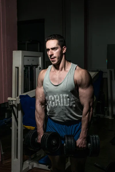 Bodybuilder doing heavy weight exercise for shoulder white dumbbell — Stock Photo, Image