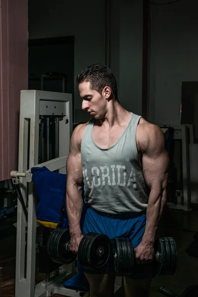 Bodybuilder doing heavy weight exercise for shoulder white dumbbell — Stock Photo, Image