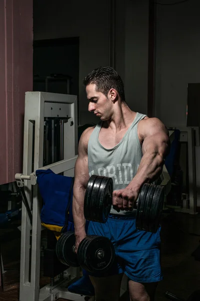 Bodybuilder doing heavy weight exercise for shoulder white dumbbell — Stock Photo, Image