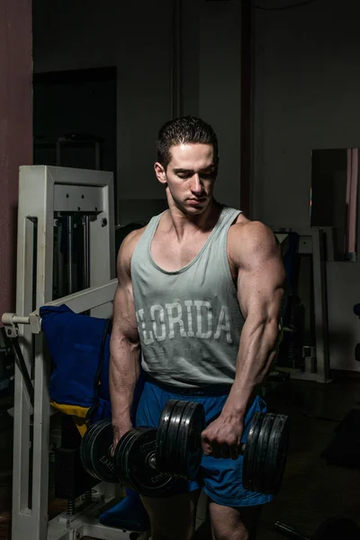 Bodybuilder doing heavy weight exercise for shoulder white dumbbell — Stock Photo, Image