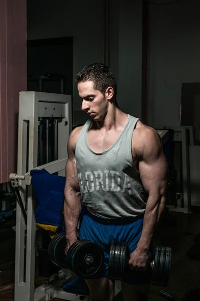 Bodybuilder doing heavy weight exercise for shoulder white dumbbell — Stock Photo, Image