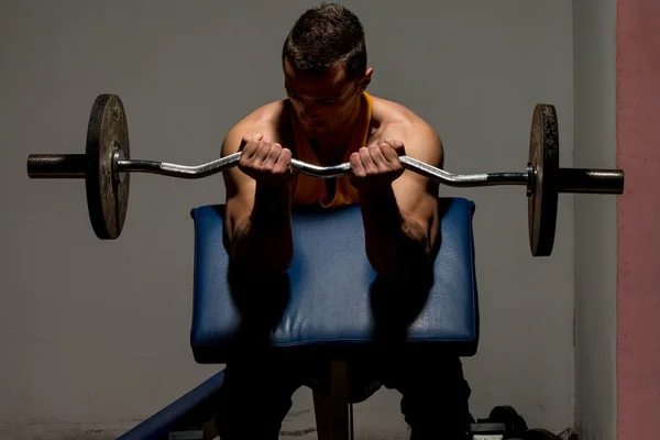 Entraîneur de remise en forme faisant un exercice de poids lourd pour biceps — Photo