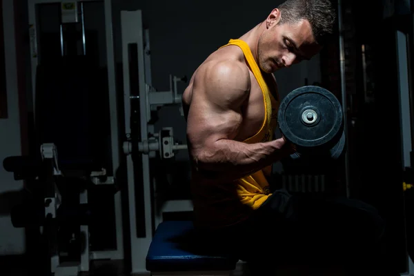 Young man doing heavy weight exercise for biceps — Stock Photo, Image