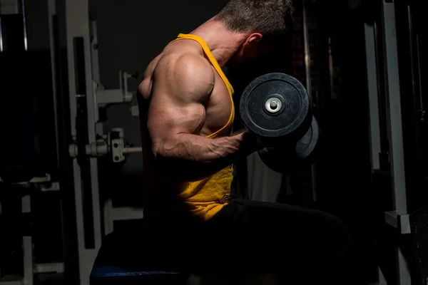 Young man doing heavy weight exercise for biceps — Stock Photo, Image