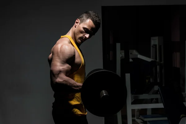 Young man doing heavy weight exercise for biceps — Stock Photo, Image