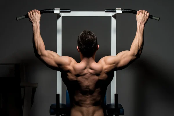 Jovem fisiculturista do sexo masculino fazendo exercício pesado — Fotografia de Stock